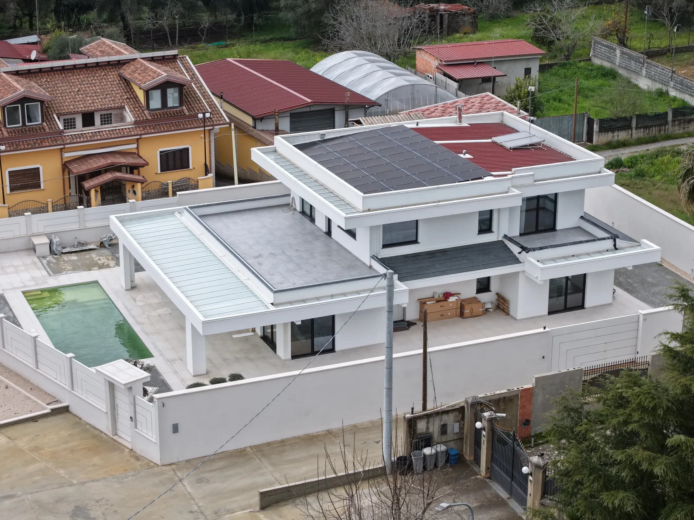 Villa residenziale a Polistena (RC) realizzata da Ecolive: abitazione moderna a tetto piano con piscina, pannelli fotovoltaici e ampi terrazzi