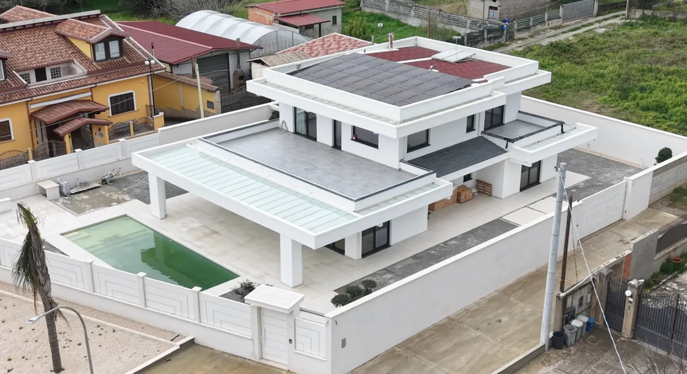 Vista aerea della villa Ecolive a Polistena: volume bianco contemporaneo su due livelli con copertura piana e area piscina