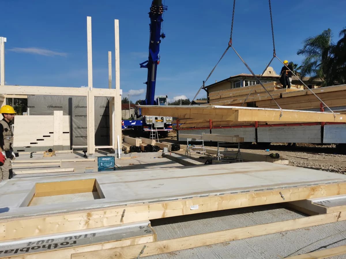 Gru solleva pannello prefabbricato X-Frame in cantiere EcoLive